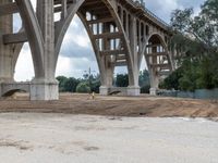 a construction site with many different levels of bridge under construction and a man walking toward the left