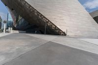 a man in white is outside a building and looks up at something, like a large, angled building