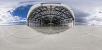 a fisheye lens in the middle of an airport and clouds are in the background