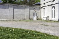 a cement building with a bench outside next to a brick wall and concrete wall in front of it