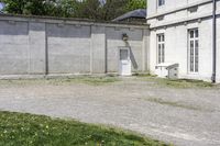 a cement building with a bench outside next to a brick wall and concrete wall in front of it