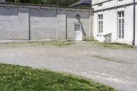 a cement building with a bench outside next to a brick wall and concrete wall in front of it