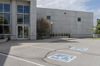 parking spaces marked in blue in front of a concrete building with multiple windows and a fire hydrant