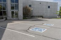 parking spaces marked in blue in front of a concrete building with multiple windows and a fire hydrant