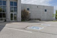 parking spaces marked in blue in front of a concrete building with multiple windows and a fire hydrant