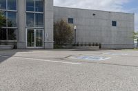 parking spaces marked in blue in front of a concrete building with multiple windows and a fire hydrant