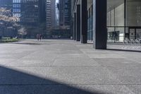 there are many bike racks in the middle of a sidewalk and walkway, with an office building behind them