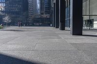 there are many bike racks in the middle of a sidewalk and walkway, with an office building behind them