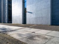 the sidewalk in front of the buildings has cobblestone stones laid on it and no one is standing