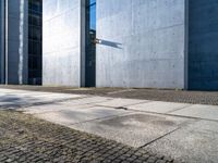 the sidewalk in front of the buildings has cobblestone stones laid on it and no one is standing