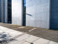 the sidewalk in front of the buildings has cobblestone stones laid on it and no one is standing