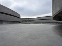 a building with cement roof near green grass and lawn in front of it, under a gray sky