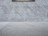 the skateboarder does a trick on the concrete floor of a skate park while wearing sunglasses