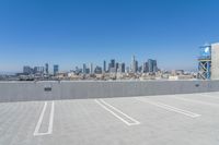 the top of a building with an elevated parking lot next to it and the city in the background