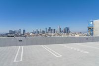 the top of a building with an elevated parking lot next to it and the city in the background