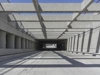 a long open road with many gray cement walls and pillars in the middle of the road