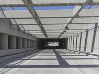 a long open road with many gray cement walls and pillars in the middle of the road