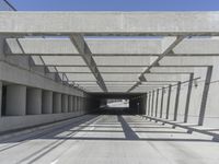 a long open road with many gray cement walls and pillars in the middle of the road