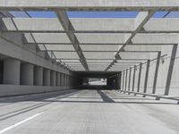 a long open road with many gray cement walls and pillars in the middle of the road