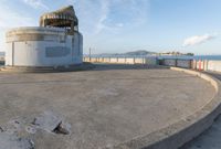 an old concrete observation tower stands in the middle of the city in the distance, overlooking the skyline