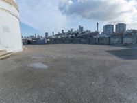 an old concrete observation tower stands in the middle of the city in the distance, overlooking the skyline