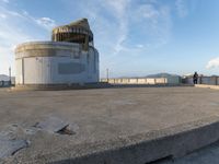 an old concrete observation tower stands in the middle of the city in the distance, overlooking the skyline