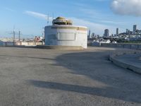 an old concrete observation tower stands in the middle of the city in the distance, overlooking the skyline