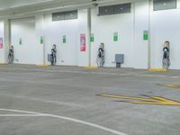 three men are charging their electric vehicles at an electric car park in a building,