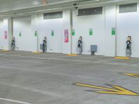 three men are charging their electric vehicles at an electric car park in a building,