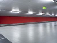 a parking garage with the floor red and white painted in black and gray and an empty yellow sign