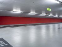 a parking garage with the floor red and white painted in black and gray and an empty yellow sign