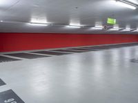 a parking garage with the floor red and white painted in black and gray and an empty yellow sign