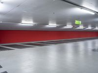 a parking garage with the floor red and white painted in black and gray and an empty yellow sign