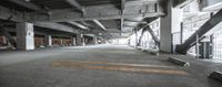 empty garage area with concrete floor and walls and two benches underneath each roof and one sitting on the floor