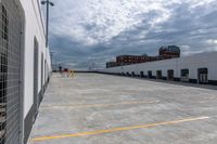 a parking garage has yellow lines on the ground of it and blue sky in the background