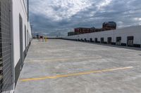 a parking garage has yellow lines on the ground of it and blue sky in the background