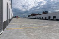 a parking garage has yellow lines on the ground of it and blue sky in the background