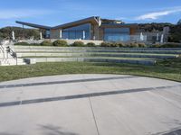 a concrete skateboard ramp going up the side of a hill by some stairs in front of a house