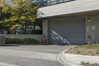 a gray garage is shown with its doors open and a fire hydrant in the driveway