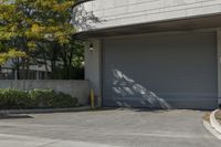 a gray garage is shown with its doors open and a fire hydrant in the driveway