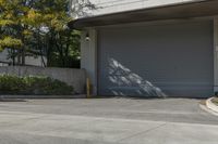 a gray garage is shown with its doors open and a fire hydrant in the driveway