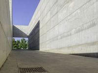 a concrete sidewalk and concrete walls near an opening on top of the building to allow people to access the space