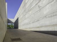 a concrete sidewalk and concrete walls near an opening on top of the building to allow people to access the space