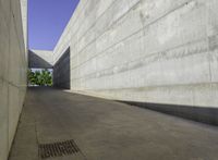 a concrete sidewalk and concrete walls near an opening on top of the building to allow people to access the space