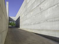 a concrete sidewalk and concrete walls near an opening on top of the building to allow people to access the space