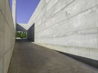 a concrete sidewalk and concrete walls near an opening on top of the building to allow people to access the space