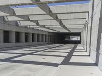 concrete and steel structure with low shadows, in an open parking lot, with empty spaces for cars and pedestrians