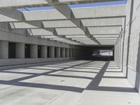 concrete and steel structure with low shadows, in an open parking lot, with empty spaces for cars and pedestrians