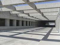 concrete and steel structure with low shadows, in an open parking lot, with empty spaces for cars and pedestrians