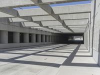 concrete and steel structure with low shadows, in an open parking lot, with empty spaces for cars and pedestrians